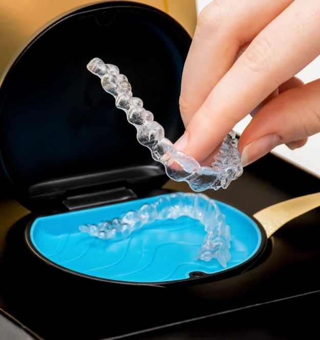 Close up of a hand holding an aligner